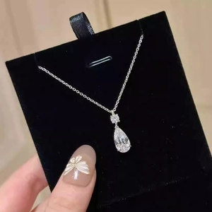 Detail of a pear-cut teardrop pendant necklace in polished silver with clear crystals