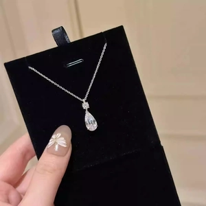 Elegant silver teardrop pendant necklace with sparkling pear-cut stone on a velvet card