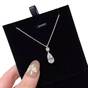 Elegant teardrop pear-cut gemstone pendant necklace with silver chain on black velvet