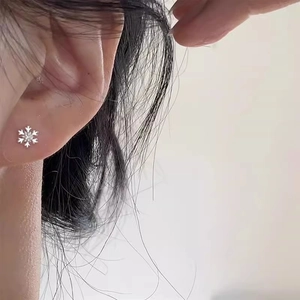 Boucles d'oreilles flocon de neige en argent avec cristal central portées par mannequin