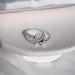 Minimalist silver meteor ring with three star charms and woven texture on white display