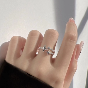 Minimalist silver meteor ring with three stars and adjustable braided band on hand