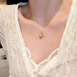Elegant gold necklace with pink zircon pinecone pendant on a delicate cross chain