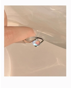 Macro view of minimalist silver stream ring with iridescent round synthetic opal stone