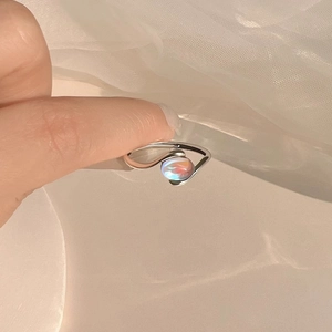 Minimalist silver ring with iridescent opal-like stone in a sleek bypass design