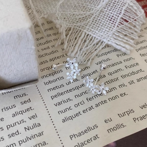 Elegant floral cluster screw-back silver earrings on a vintage paper and lace background