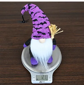 Halloween gnome plush with purple bat hat and broom, weighing 121.1g on a scale