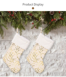 Detail of cream Christmas stockings with golden branch patterns and white faux fur trim