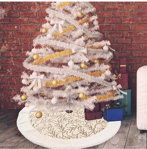 Close-up of white plush Christmas tree skirt with gold berry branches and faux fur trim