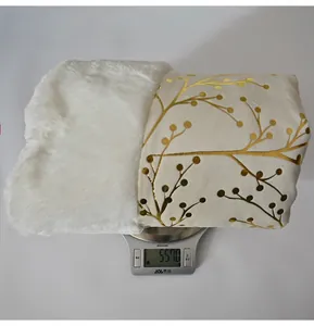 Detail of plush Christmas tree skirt weighing 557g with gold branch pattern and faux fur
