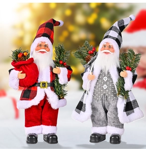 Detail von zwei Weihnachts-Weihnachtsmann-Figuren mit Karomuster und Kiefernnadeln