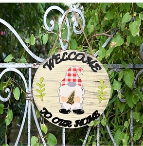 Detail of wooden welcome sign with festive gnome and Christmas tree for home wall decor