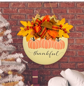 Détail d'une suspension citrouille en bois avec feuilles d'érable baies et mot thankful