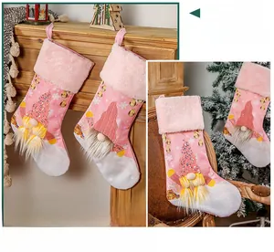 Calza natalizia rosa con gnomo luminoso e paillettes in un accogliente ambiente domestico