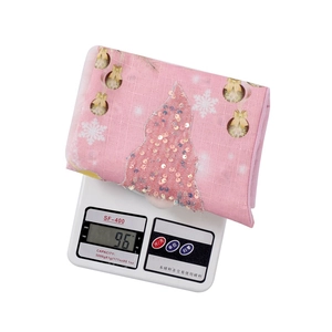 Calza di Natale rosa con motivi di alberi di paillettes che mostra il peso sulla bilancia