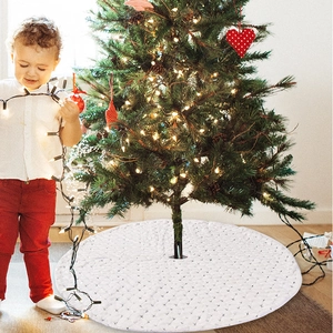 Detail of white quilted Christmas tree skirt with festive lights and holiday atmosphere
