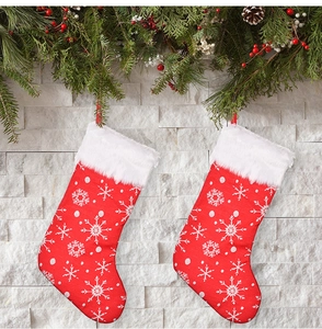 Detail view of red Christmas stockings with embroidered snowflakes and white faux fur trim