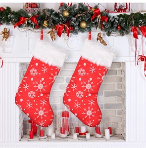 Close-up of two red embroidered snowflake Christmas stockings hanging on a white fireplace