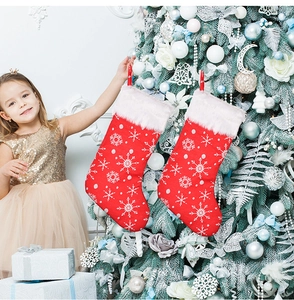 Close-up of red Christmas stockings with embroidered snowflakes and white faux fur trim