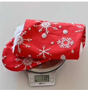 Detail view of red Christmas stocking with white snowflake embroidery weighing 118.4g