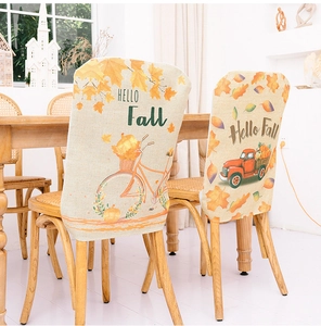 Close-up of Hello Fall chair covers with pumpkin bicycle and maple leaf motifs