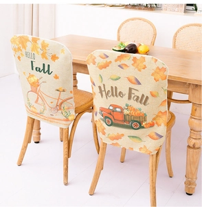 Close-up of autumn harvest chair covers with pumpkin truck and maple leaf patterns