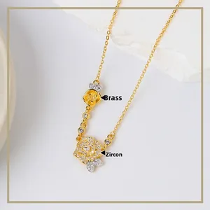 Dettaglio macro della collana a due rose dorate con petali in ottone e zirconi pavé