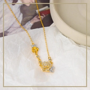 Collana di lusso francese in oro con due rose e zirconi pavé su carta bianca