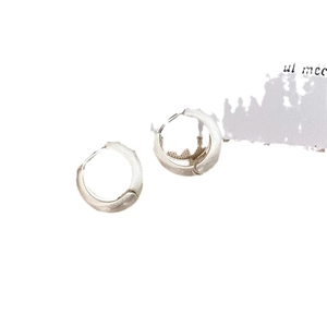 Orecchini a goccia in argento opaco minimalisti con texture spazzolata su sfondo bianco