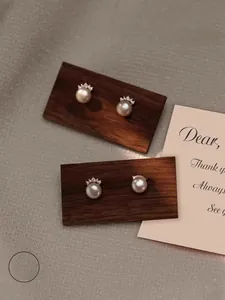 Macro detail of S925 sterling silver crown pearl earrings with sparkling zircon accents