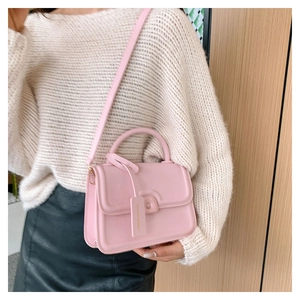 Pink minimalist square handbag with top handle and shoulder strap shown on a model
