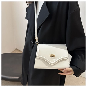 Minimalist white crossbody bag detail with golden oval swivel lock and smooth PU leather