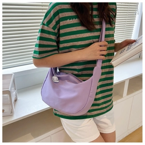 Détail du sac bandoulière en velours côtelé violet avec breloque chien sur la fermeture