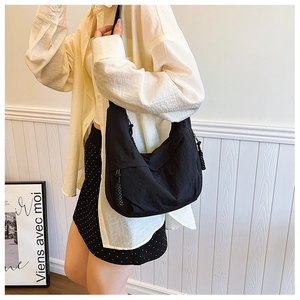 Detalle del bolso hobo de nailon impermeable negro con forma de media luna y cordón trenzado