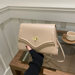 Minimalist beige matte leather shoulder bag with vintage gold oval turn-lock closure