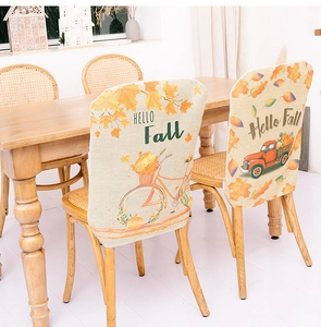 Detail of harvest festival chair covers with pumpkins, autumn leaves and Hello Fall text