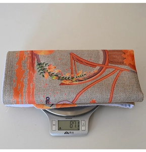 Close-up showing the 87.1g weight of an autumn pumpkin print fabric chair cover on a scale