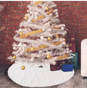Detail of white plush Christmas tree skirt with wavy texture under a decorated tree