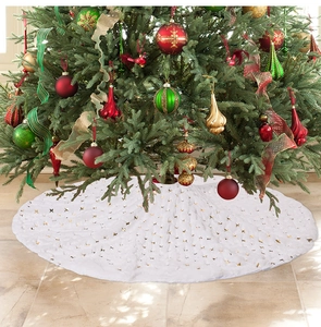 Close-up of plush white faux fur Christmas tree skirt with shiny gold sequin decorations
