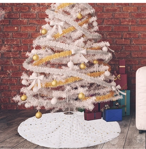 Detail of white plush Christmas tree skirt with golden sequin stars for holiday decor