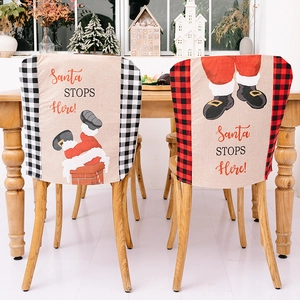 Detail of Christmas Santa chair covers with plaid trim and 'Santa STOPS Here' text