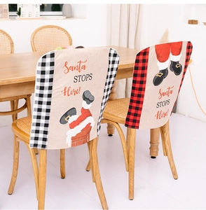 Detail of Santa STOPS Here plaid chair covers with festive Santa patterns in a dining room
