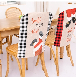 Close-up of Santa STOPS Here festive chair covers with classic plaid pattern edges