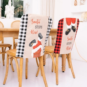 Christmas chair covers with Santa Stops Here text and festive plaid patterns on wood chairs