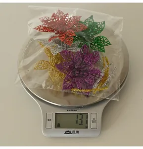 Fleurs artificielles de Noël pailletées pesant 13,1 g sur une balance de cuisine
