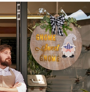 Macro detail of wooden gnome door sign with gold lettering and festive greenery decor