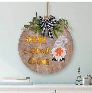 Detail of wooden door sign with Gnome Sweet Gnome text and black white plaid bow decoration
