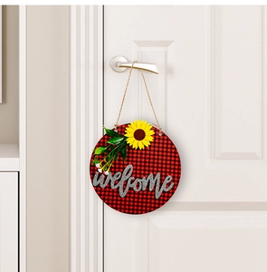 Detail of wooden welcome sign with buffalo plaid pattern and sunflower on a white door