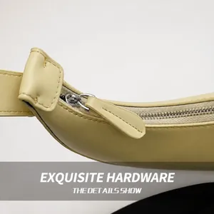 Detail of cream yellow leather bag featuring smooth silver zipper and neat stitching