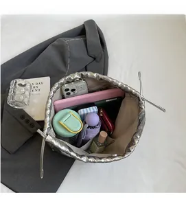Interno spazioso della borsa tote argento con catena che mostra gli oggetti quotidiani
